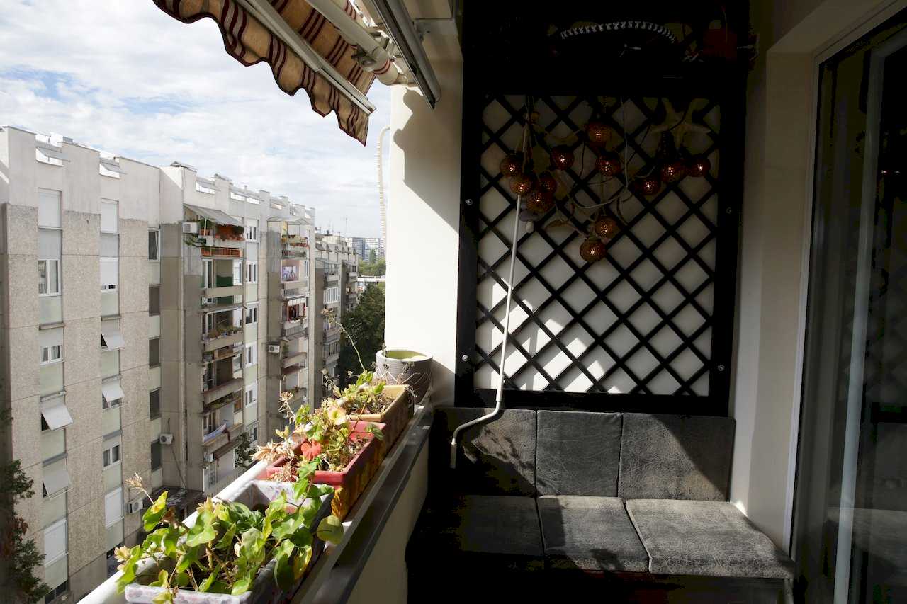 Terrace with bench seating, plants and building view – Apartment Arena – City Break Apartments