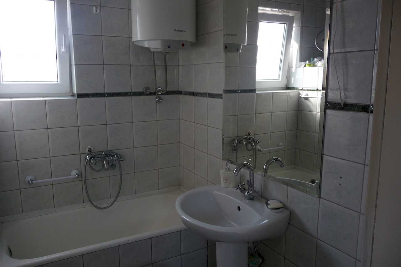 Kupatilo sa kadom i umivaonikom, pločice i prozor – Apartman Belgrade Sky – City Break Apartments