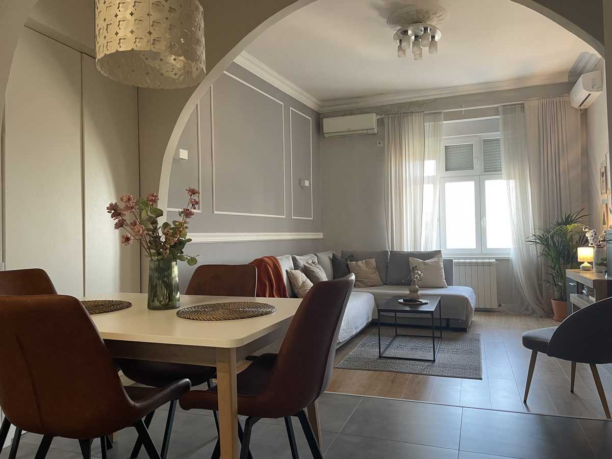 Dining table for four and view into the living area through the arch – Apartment Cityzen – City Break Apartments
