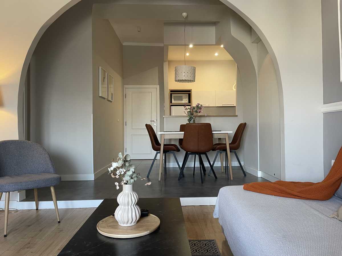 View from the living room toward the dining area and kitchen behind the arch (open plan) – Apartment Cityzen – City Break Apartments