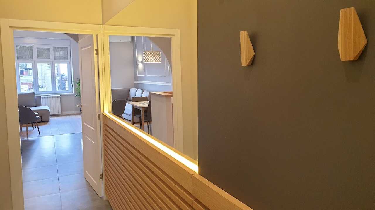 Entrance hallway with wooden paneling and LED strip lighting – Apartment Cityzen – City Break Apartments
