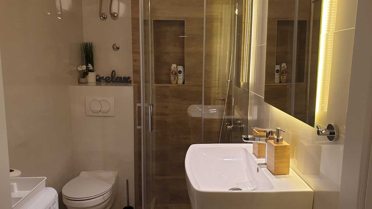 Modern bathroom with glass shower, sink and mirror – Apartment Cityzen – City Break Apartments