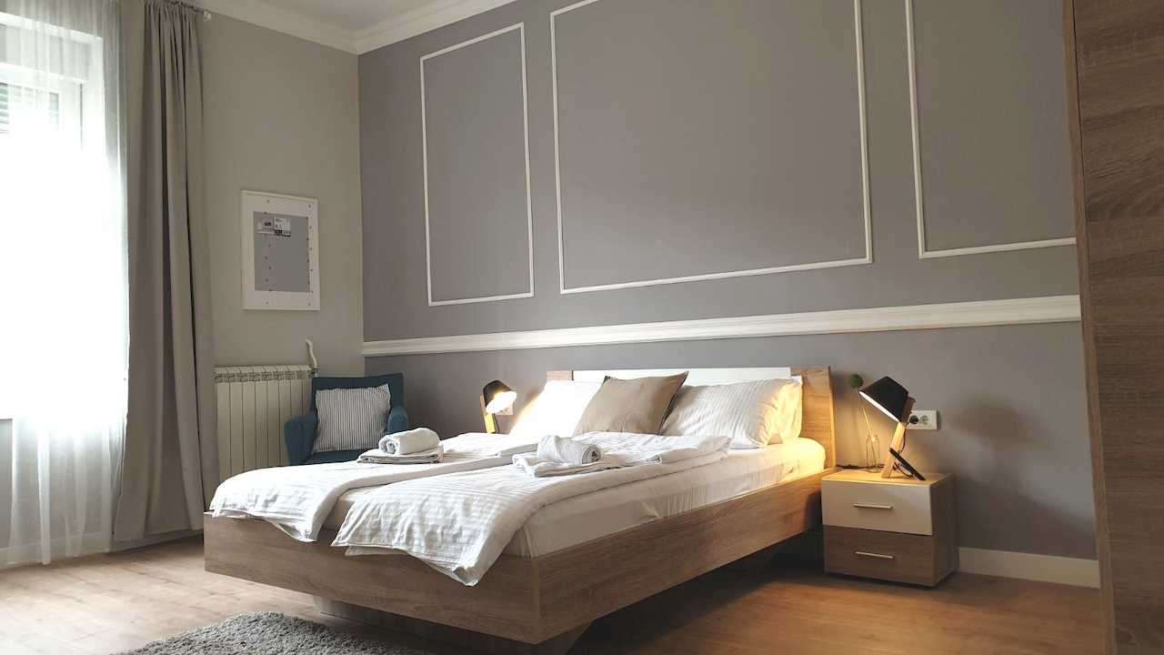 Bedroom with double bed, bedside lamps and an armchair – Apartment Cityzen – City Break Apartments