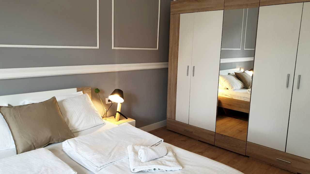 Bedroom with double bed, towels and large wardrobe – Apartment Cityzen – City Break Apartments