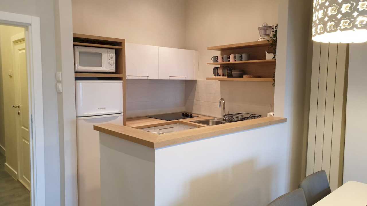 Kitchen with breakfast bar, microwave and built-in fridge niche – Apartment Cityzen – City Break Apartments