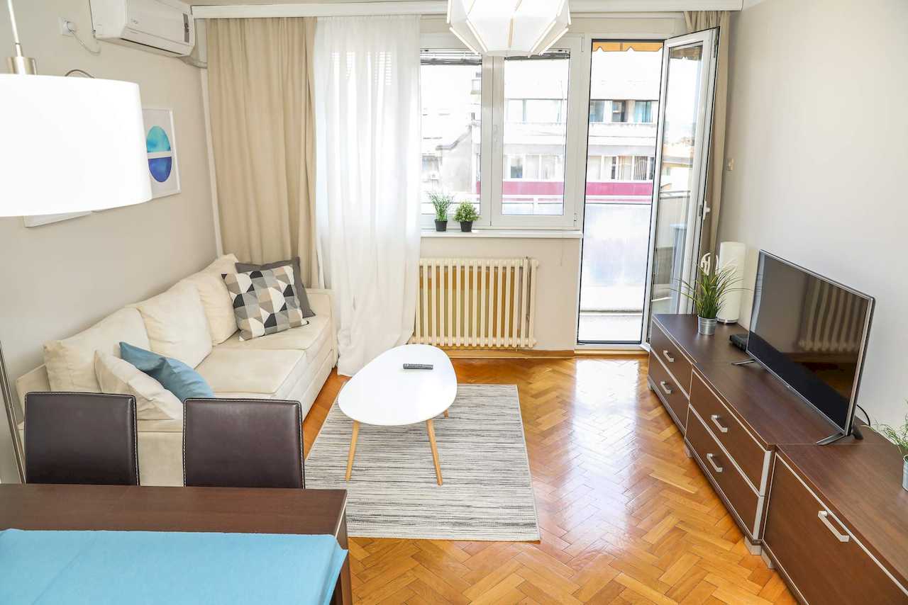 Dnevna soba sa TV komodom i izlazom na terasu – Apartman Dolce Vita – City Break Apartments