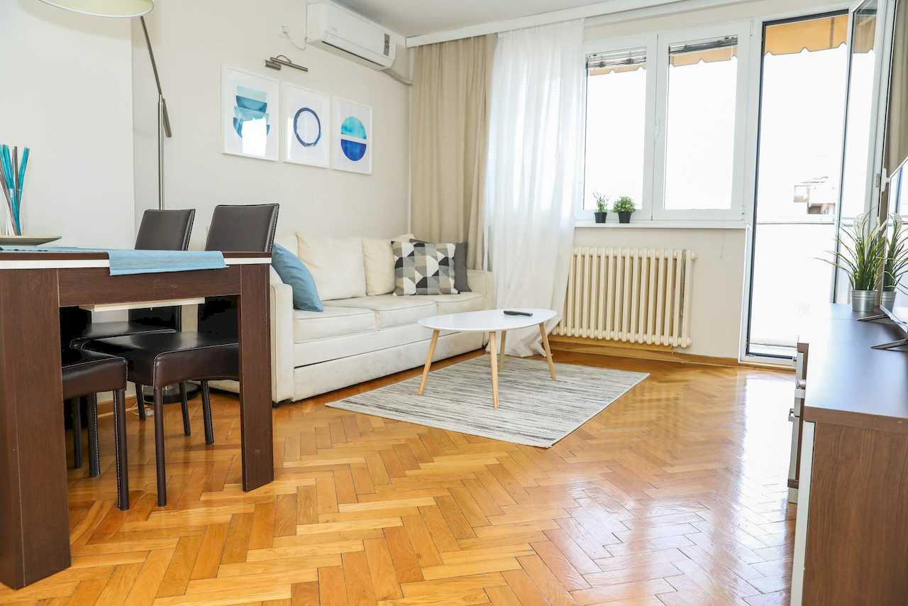 Trpezarijski deo i dnevna soba u svetlom enterijeru – Apartman Dolce Vita – City Break Apartments
