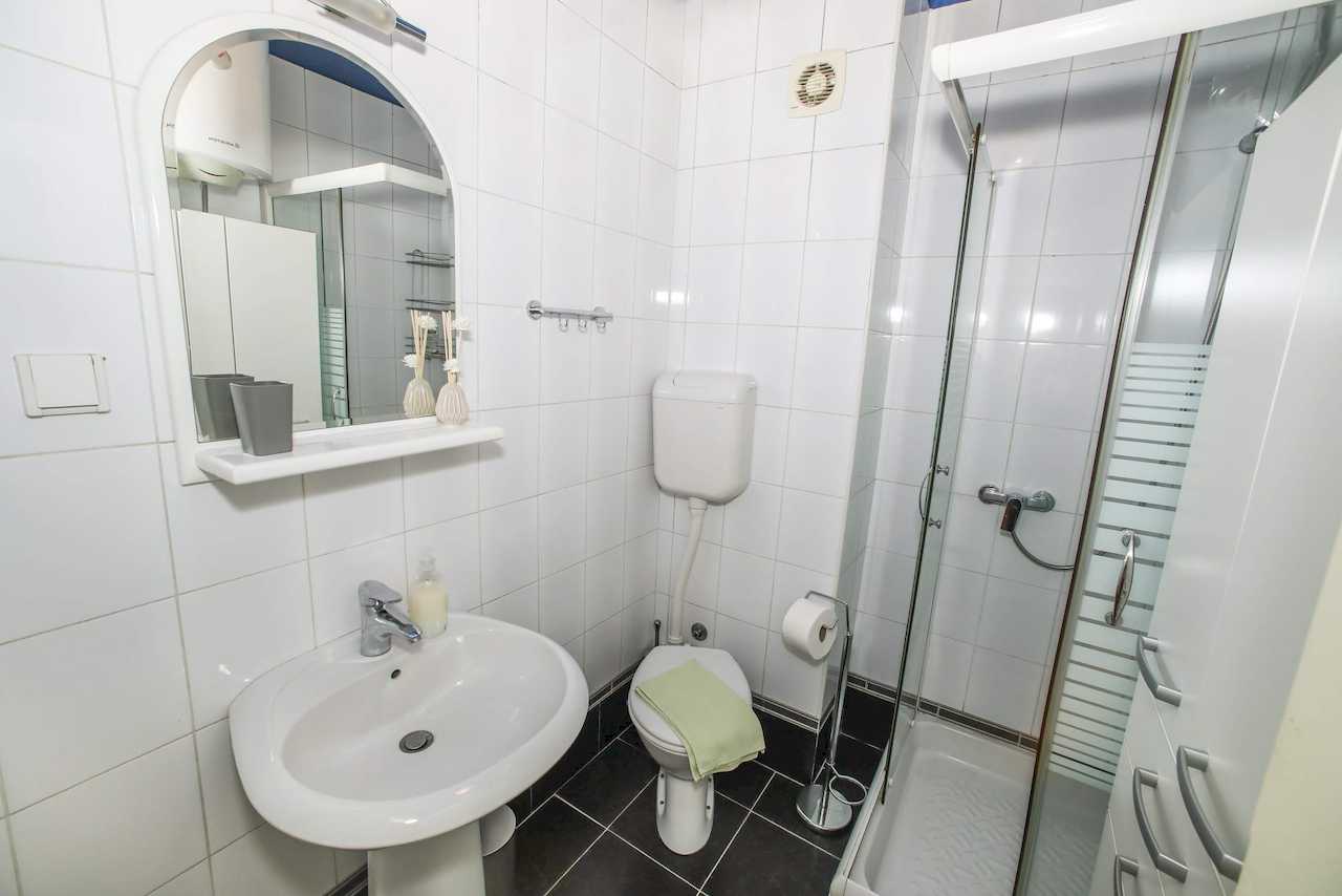 Kupatilo sa tuš kabinom, umivaonikom i ogledalom – Apartman Dolce Vita – City Break Apartments