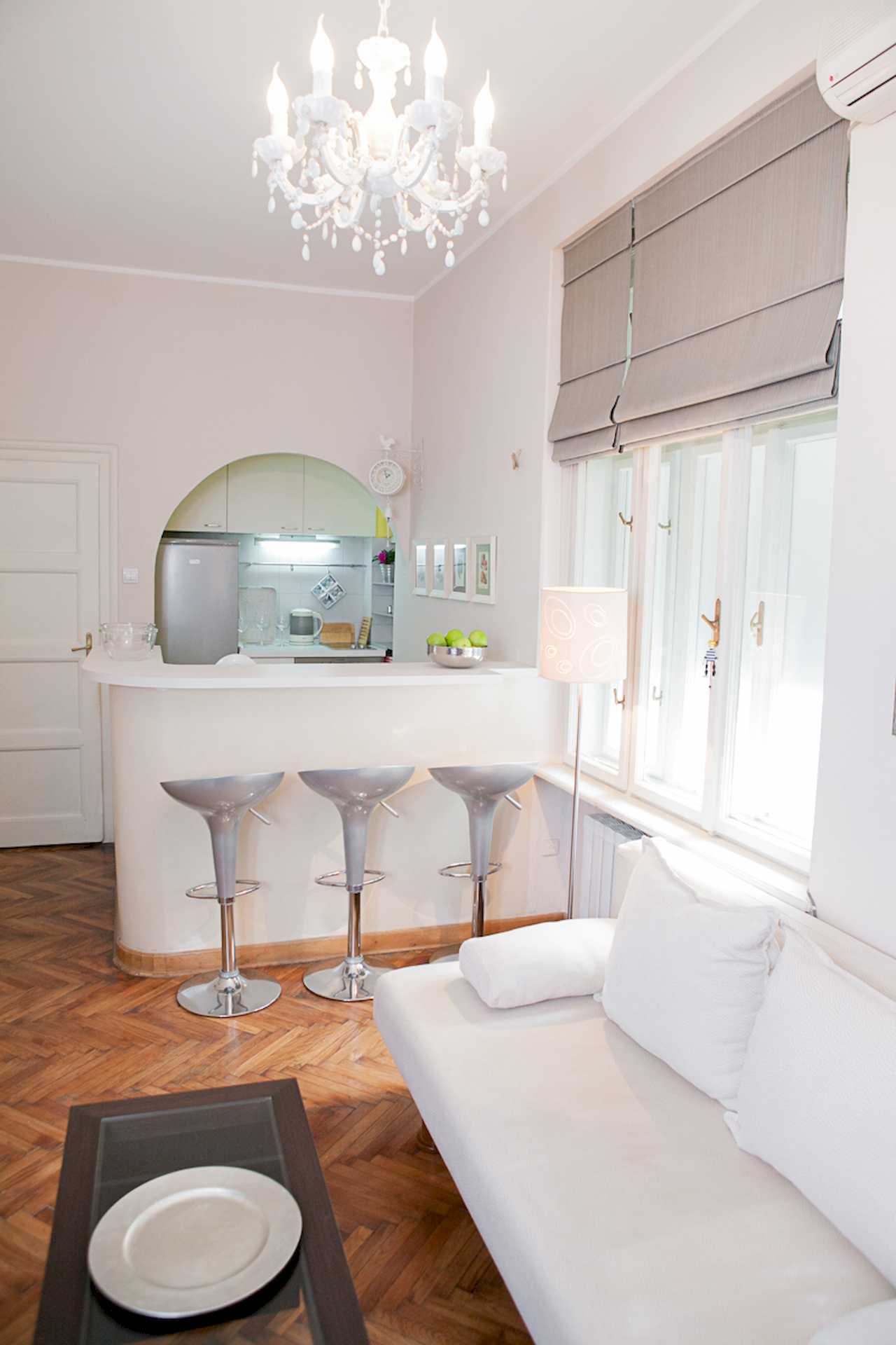 Apartment Downtown (Skadarlija, Belgrade) – living area and bar with stools, chandelier and window