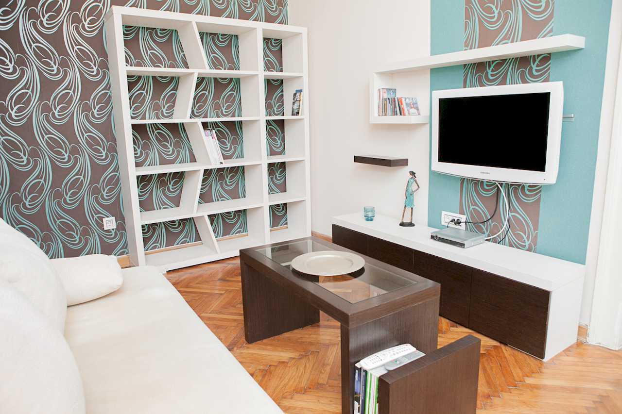 Apartment Downtown (Skadarlija, Belgrade) – living room with white sofa, sculptural bookcase and TV