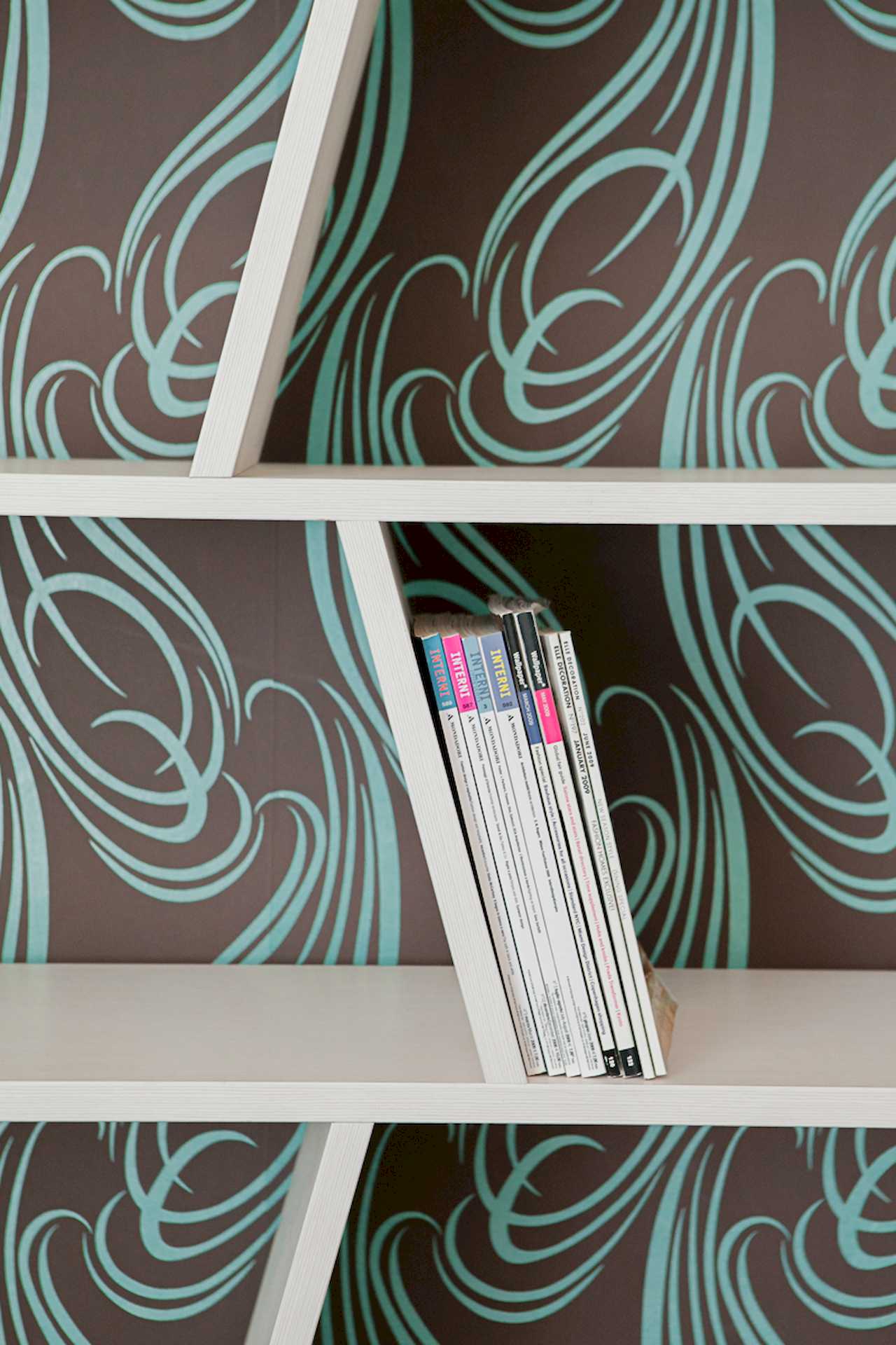 Apartment Downtown (Skadarlija, Belgrade) – white bookcase detail with magazines and patterned wallpaper