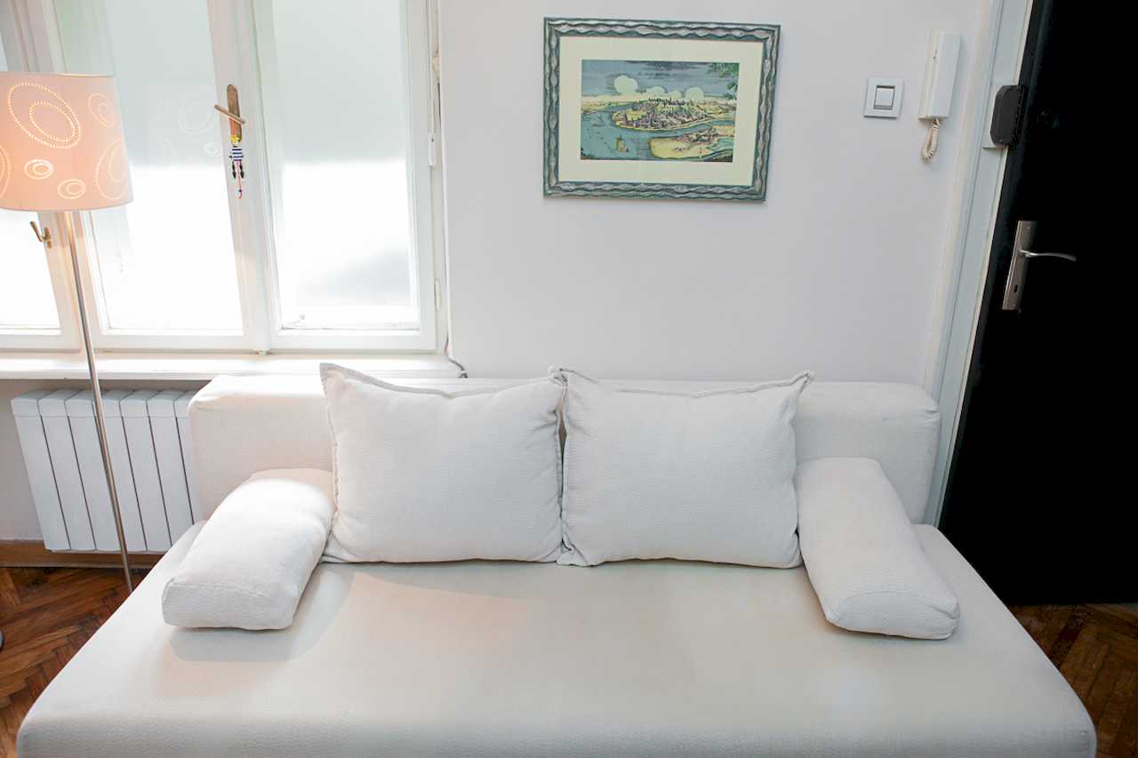 Apartment Downtown (Skadarlija, Belgrade) – white sofa detail with artwork and window