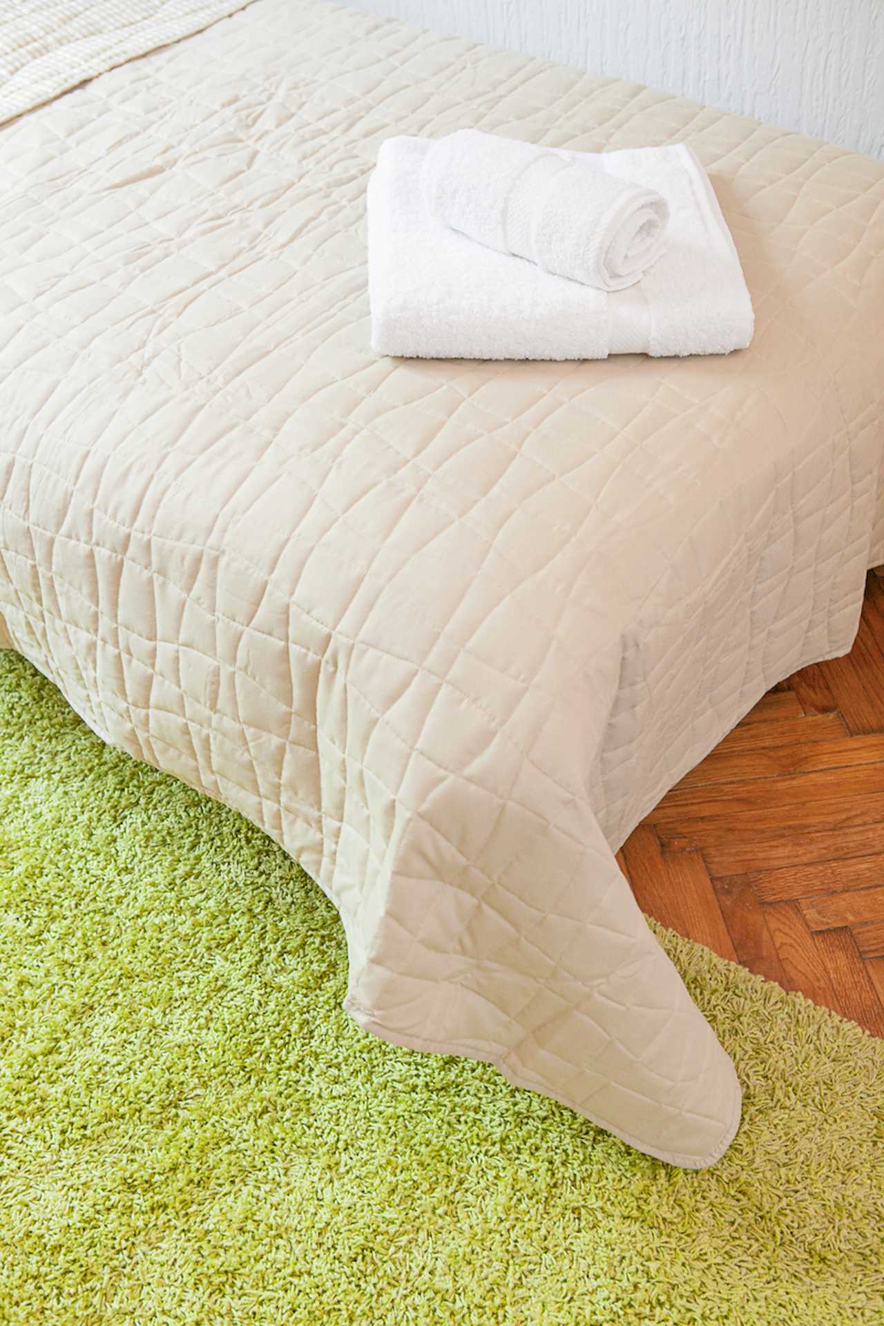 Apartment Downtown (Skadarlija, Belgrade) – bed detail with white towels and green rug