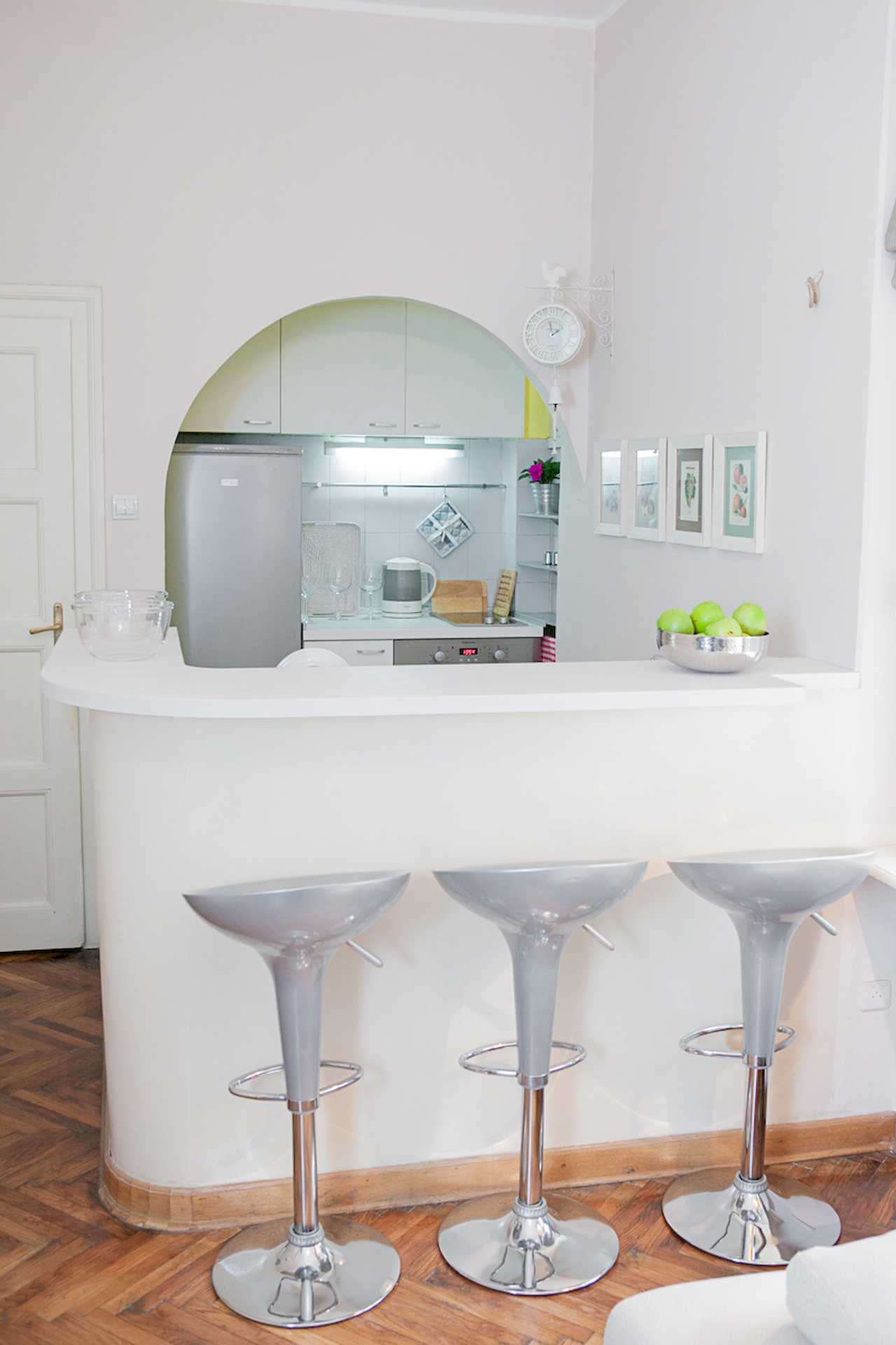 Apartment Downtown (Skadarlija, Belgrade) – bar with three stools, apples and kitchen through arch