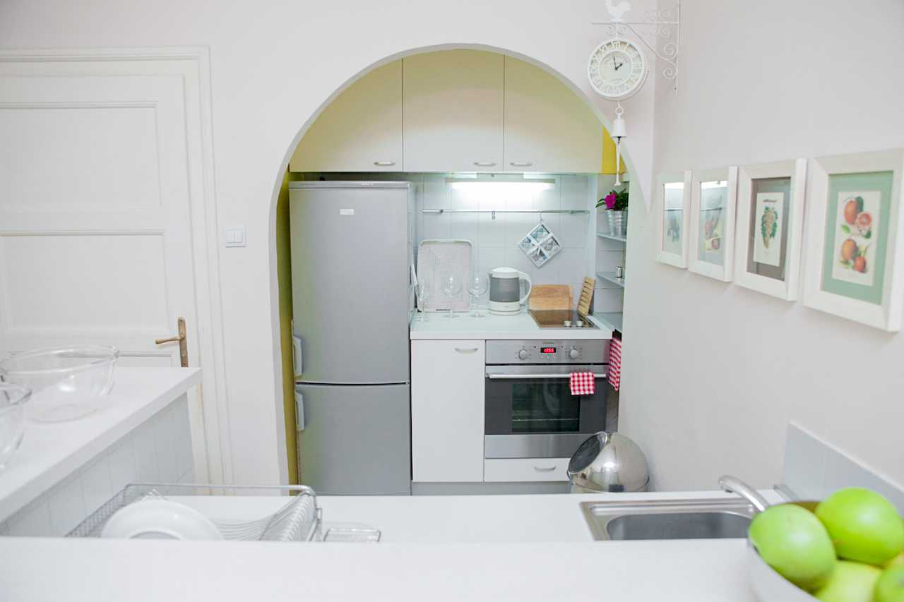 Apartment Downtown (Skadarlija, Belgrade) – view of compact kitchen through arched opening