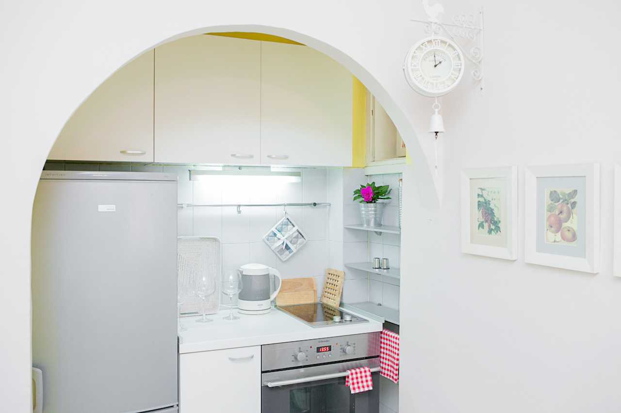 Apartment Downtown (Skadarlija, Belgrade) – white kitchen with oven and appliances through arch