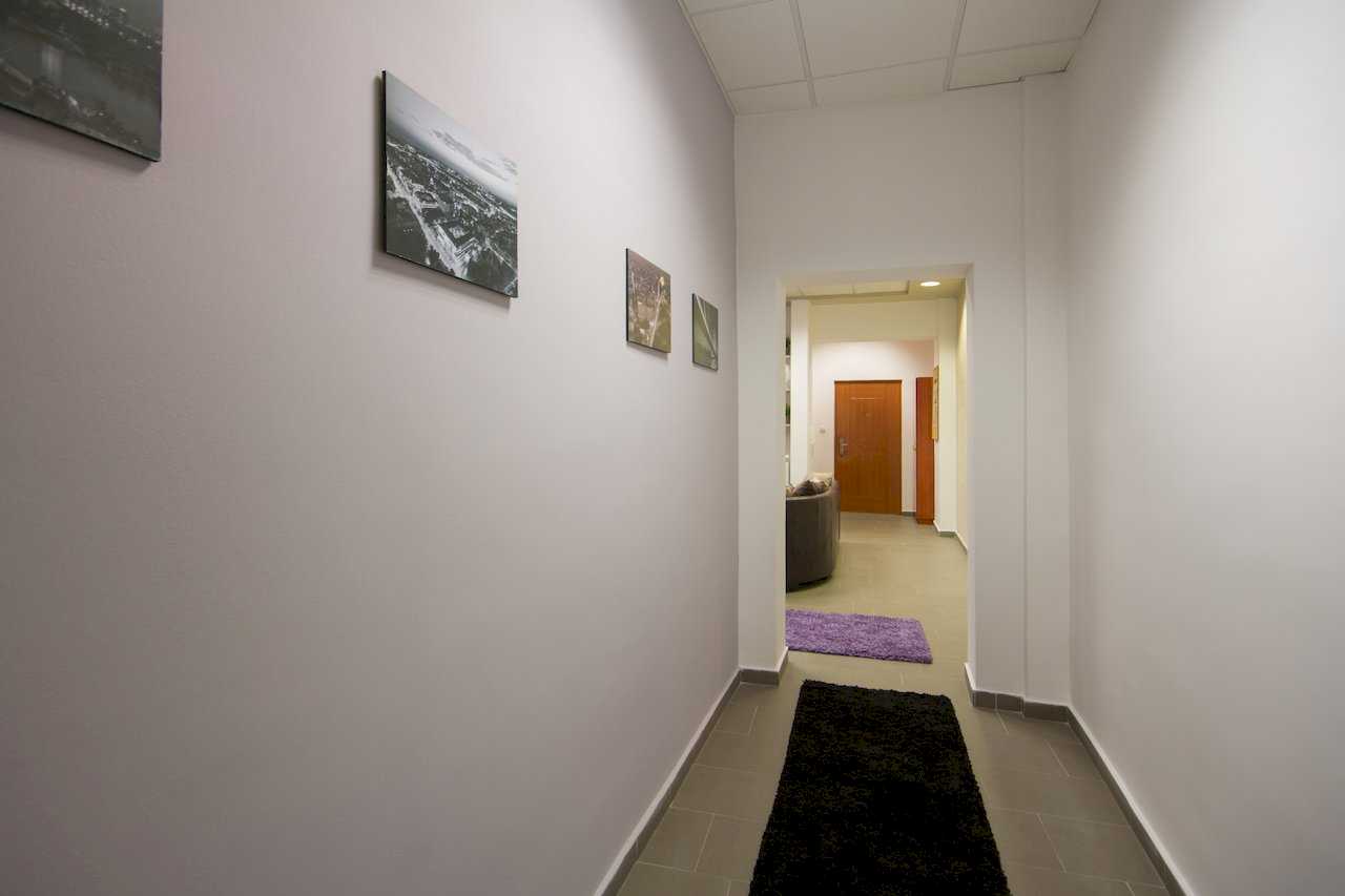 Long hallway with framed art, black and purple runners, view toward the living area and front door – Apartment Klio – City Break Apartments