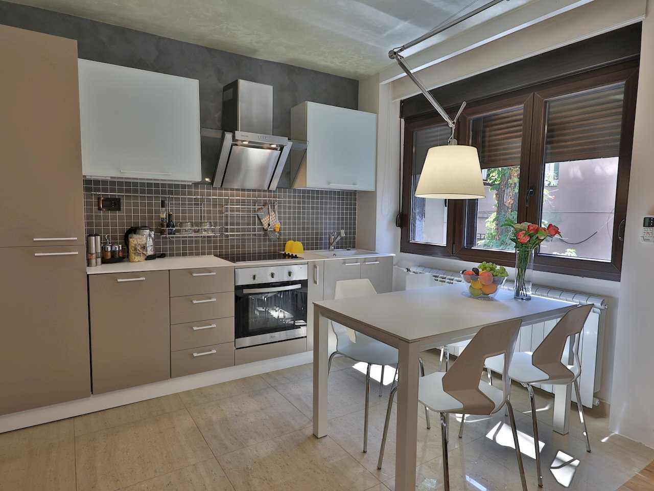 Moderna kuhinja sa sivim mozaik pločicama i trpezarijski sto sa četiri stolice – Apartman Luna Lux – City Break Apartments