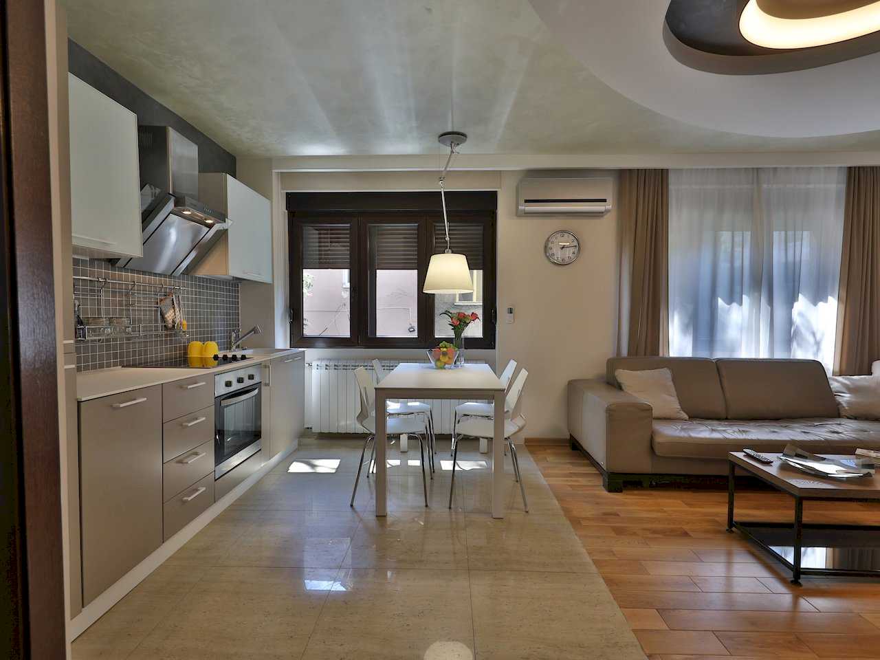 Pogled na kuhinju, trpezariju i dnevni boravak sa ugaonom garniturom – Apartman Luna Lux – City Break Apartments