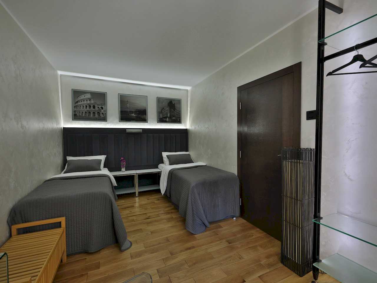 Spavaća soba sa dva kreveta i osvetljenim tapaciranim uzglavljem – Apartman Luna Lux – City Break Apartments