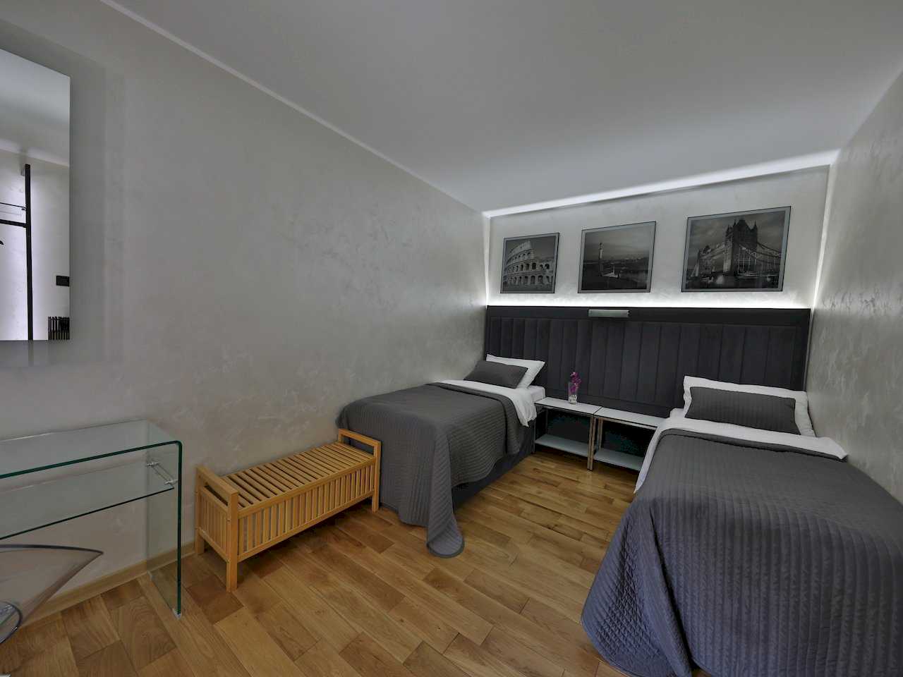 Spavaća soba sa dva kreveta i tri uokvirene fotografije znamenitosti iznad uzglavlja – Apartman Luna Lux – City Break Apartments