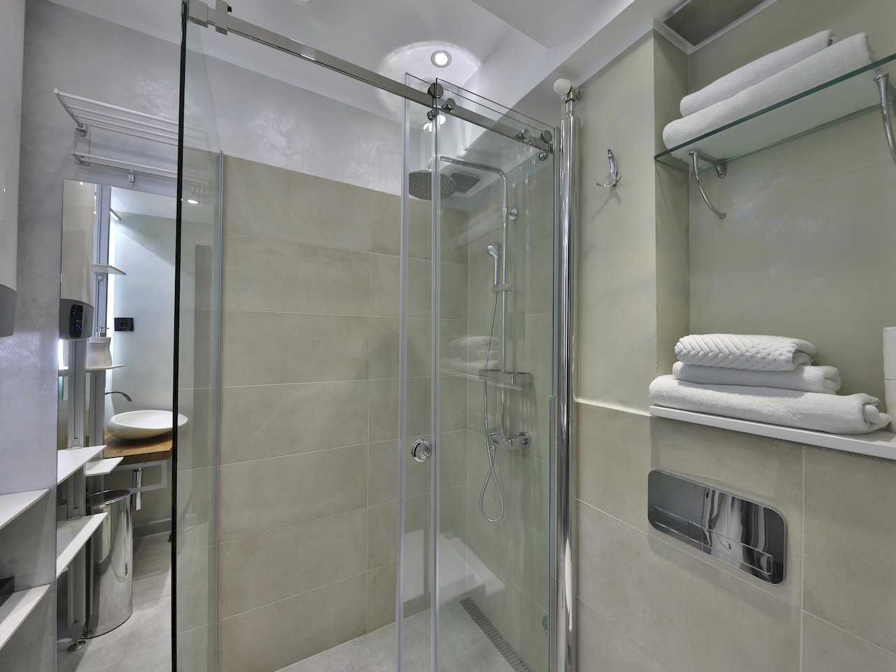 Kupatilo sa staklenom tuš kabinom i ugradnim policama za peškire – Apartman Luna Lux – City Break Apartments