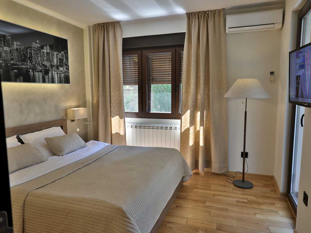 Spavaća soba sa bračnim krevetom, panoramom grada noću i TV-om – Apartman Luna Lux – City Break Apartments