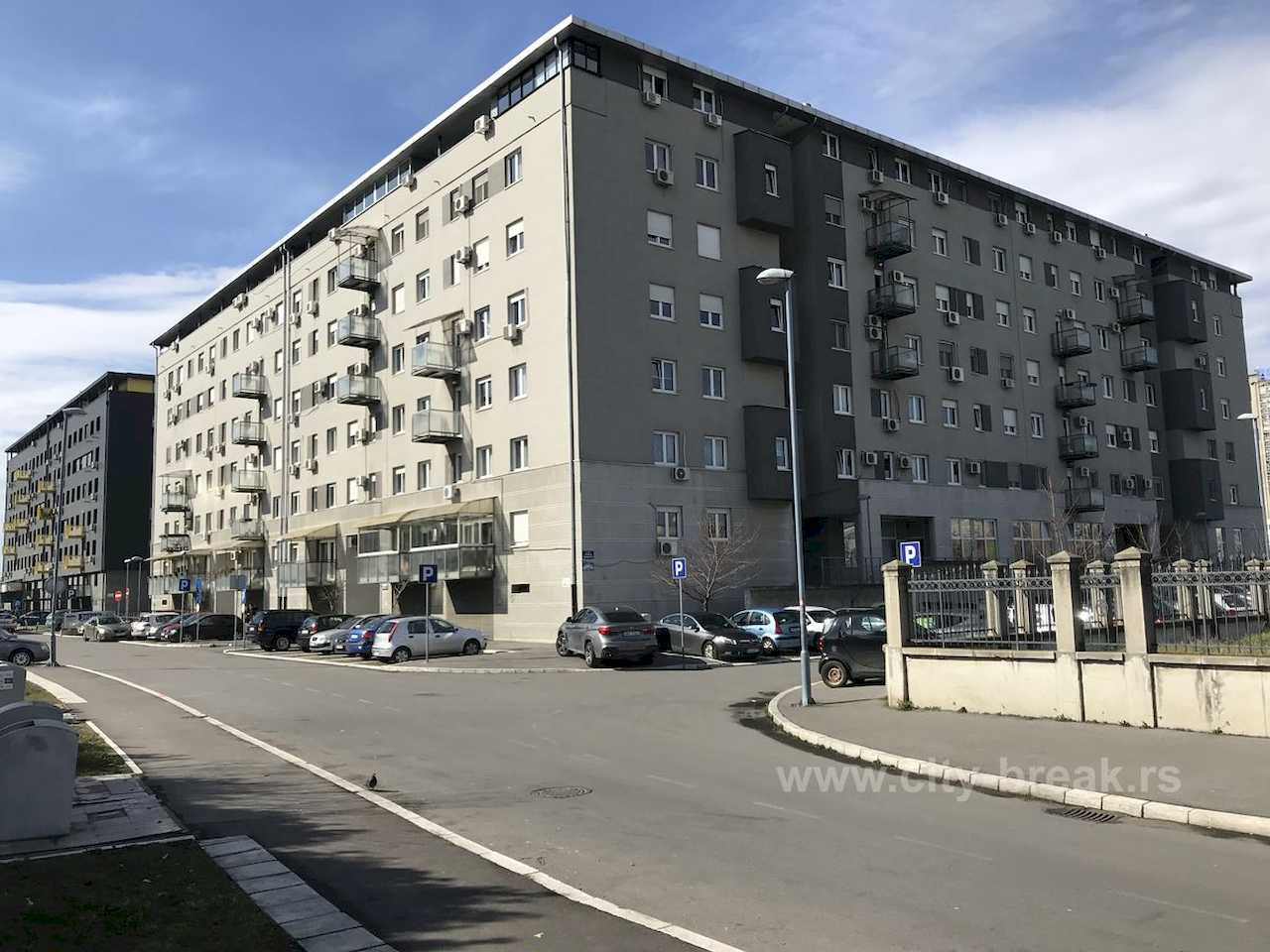 Eksterijer stambene zgrade sa parkingom ispred – Apartman Merkator – City Break Apartments