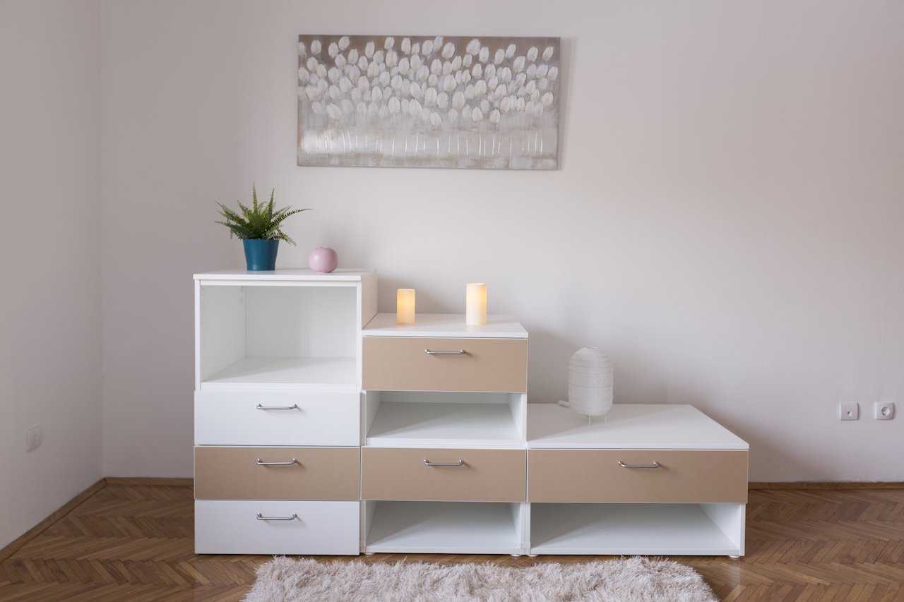 Modularna stepenasta komoda sa biljkama, svećama i apstraktnom slikom iznad – Apartman Milica – City Break Apartments