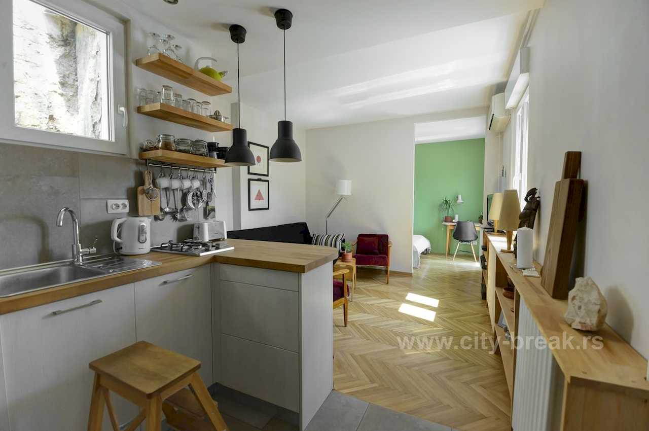 Apartman NINA (Vračar, Beograd) – otvoreni prostor: kuhinja sa šankom i dnevni boravak sa pogledom na spavaću