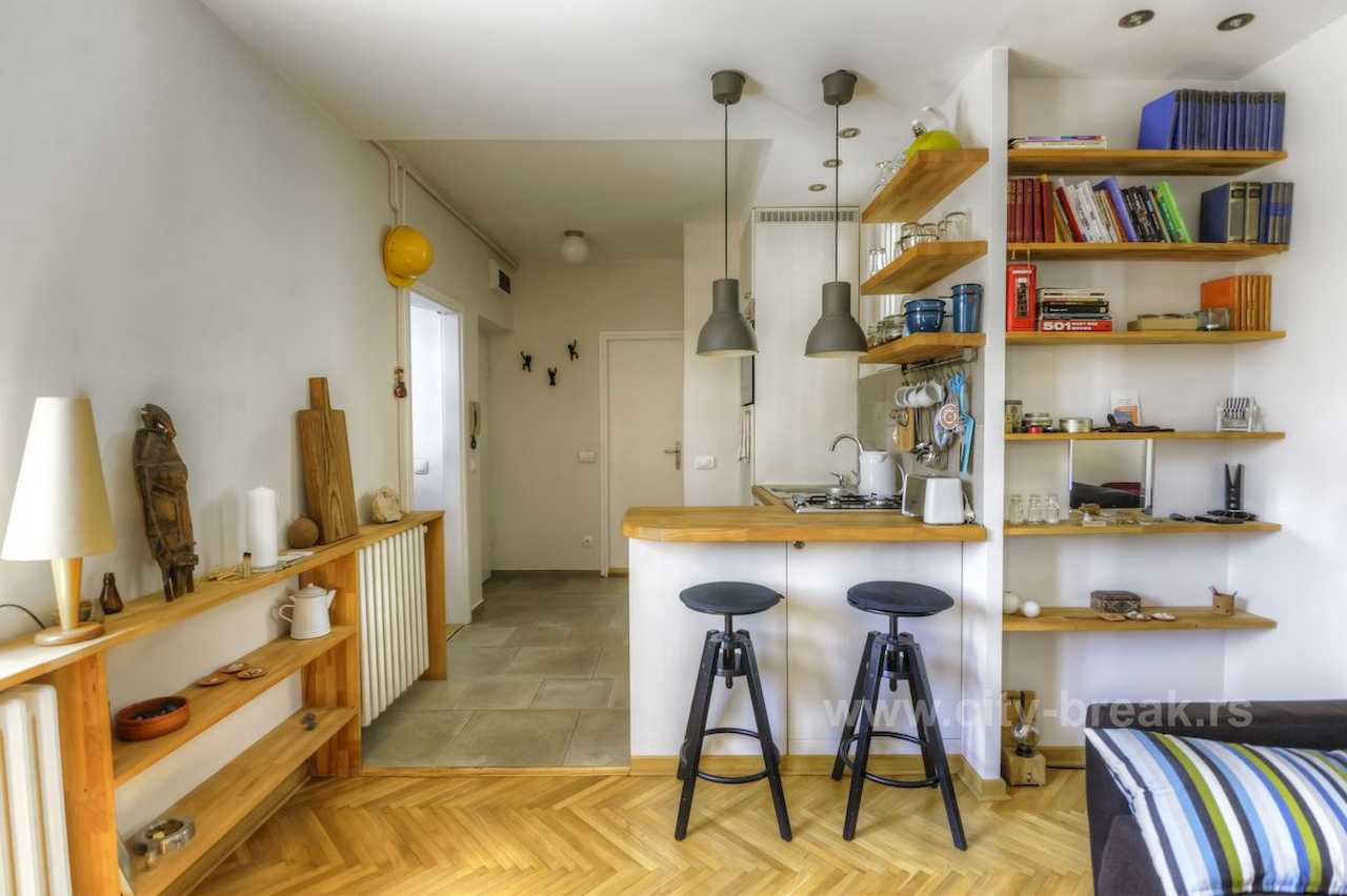 Apartman NINA (Vračar, Beograd) – kuhinja sa šankom, barskim stolicama i ugradnim policama za knjige