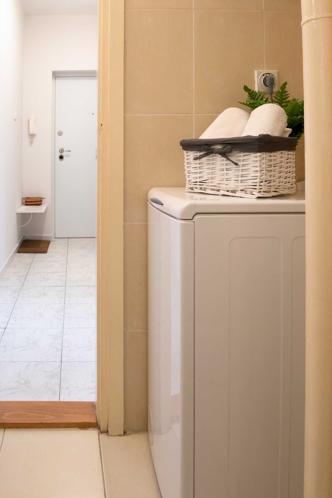 View from the bathroom toward the hallway with washing machine and front door – Apartment Oaza – City Break Apartments