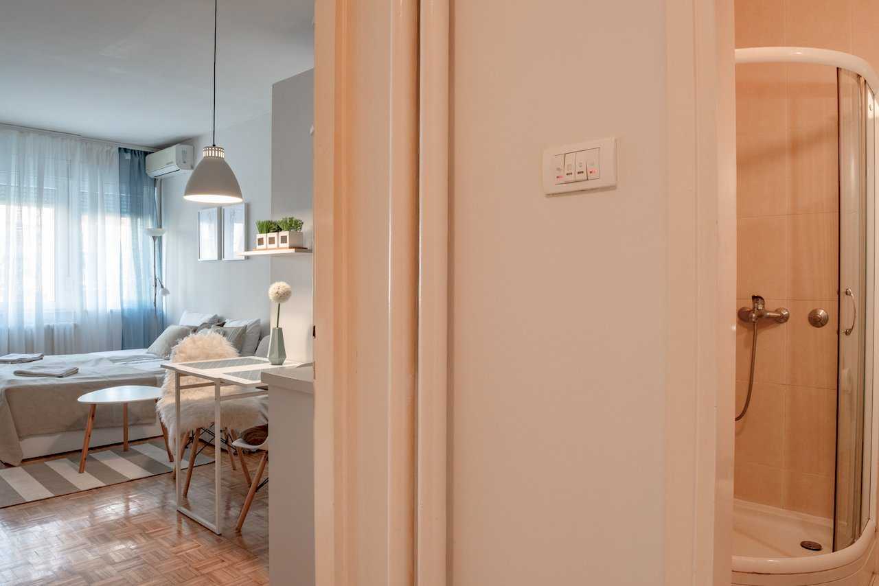 Hallway view into the sleeping area with desk and into the bathroom with shower – Apartment Oaza – City Break Apartments