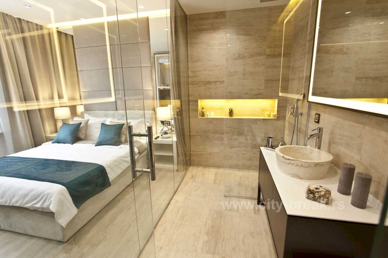 Apartman Obilić (Obilićev venac, Beograd) – kupatilo sa kamenim vessel lavaboom i walk-in tušem, pogled na bračni krevet kroz staklena vrata