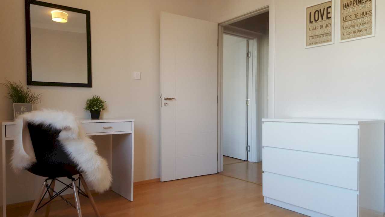 Work corner with desk, faux-fur-covered chair, dresser, LOVE and HAPPINESS art, and door ajar toward hallway – Apartment Opera – City Break Apartments