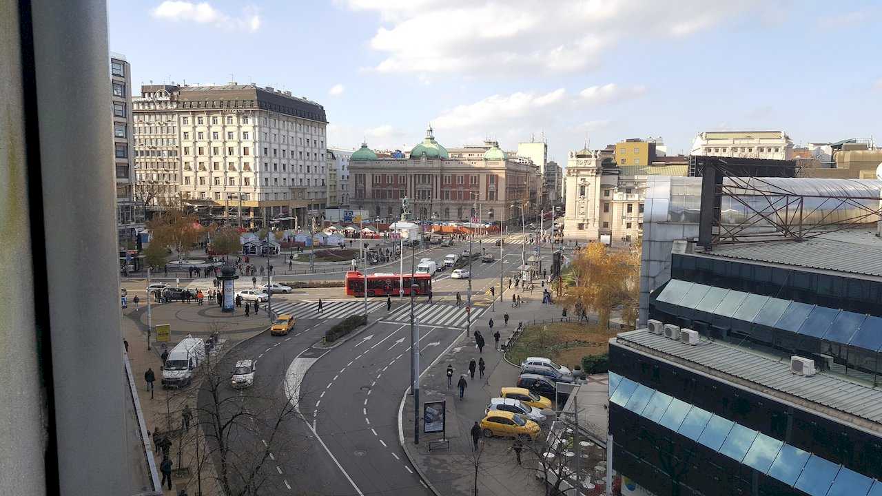 Window view of Belgrade Republic Square with Prince Mihailo monument, National Museum, and street traffic below – Apartment Opera – City Break Apartments