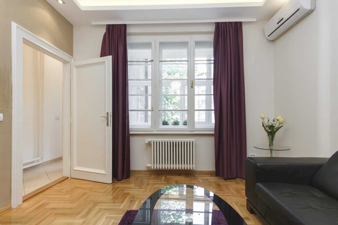 Apartment Parlament 2 (Vlajkovićeva Street, Belgrade) – living room with black sofa, purple curtains and herringbone parquet