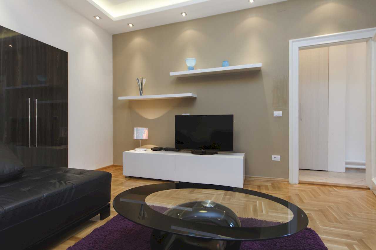 Apartment Parlament 2 (Vlajkovićeva Street, Belgrade) – living room with glass coffee table, white TV console and purple rug