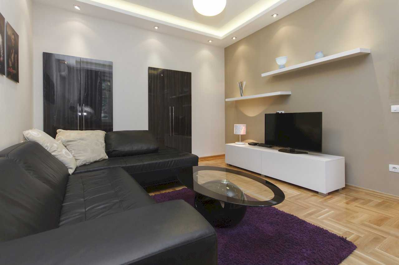 Apartment Parlament 2 (Vlajkovićeva Street, Belgrade) – living room with corner sofa and TV area on a taupe accent wall
