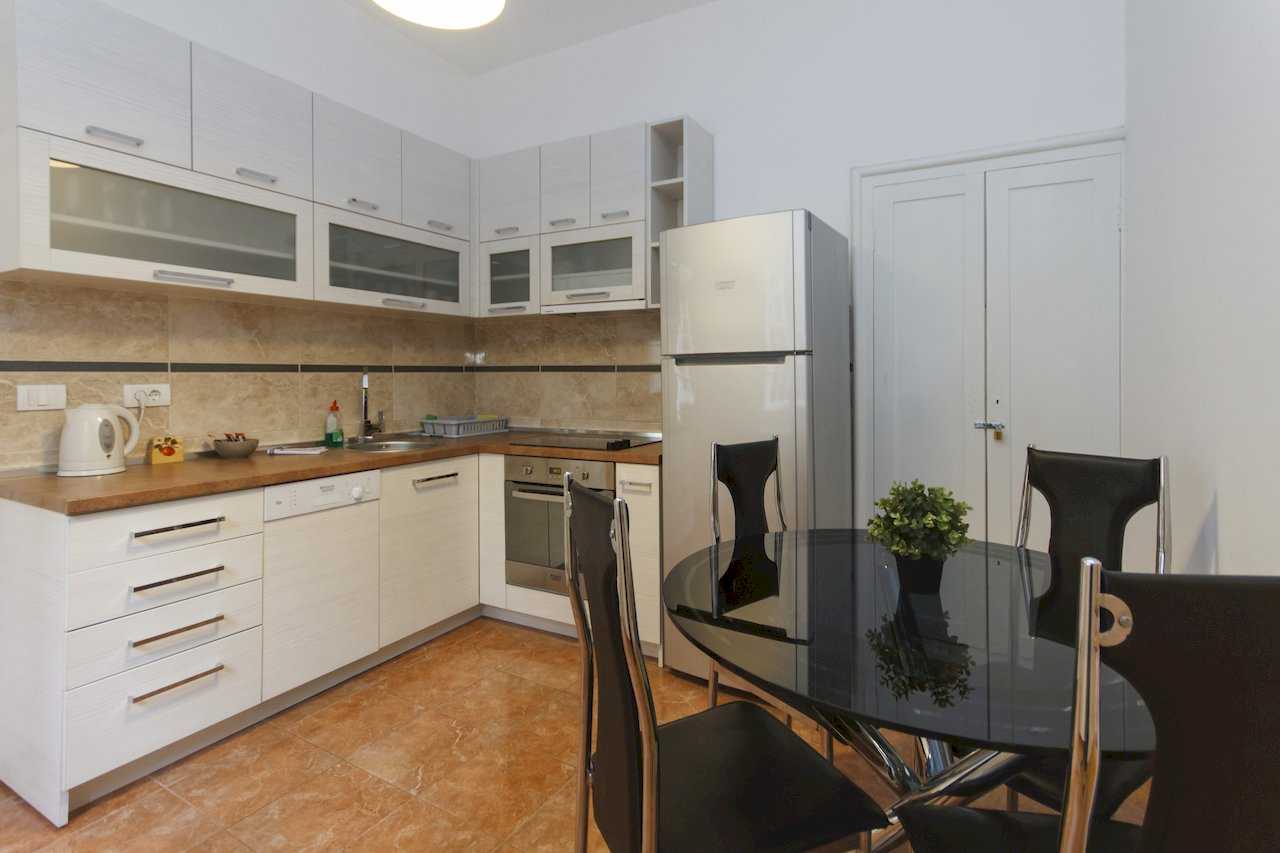 Apartment Parlament 2 (Vlajkovićeva Street, Belgrade) – L-shaped kitchen with white cabinets and black glass dining table