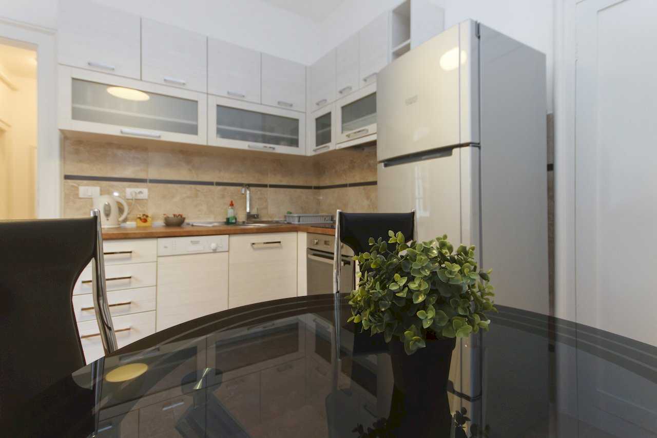 Apartment Parlament 2 (Vlajkovićeva Street, Belgrade) – dining area with black table and white kitchen cabinetry