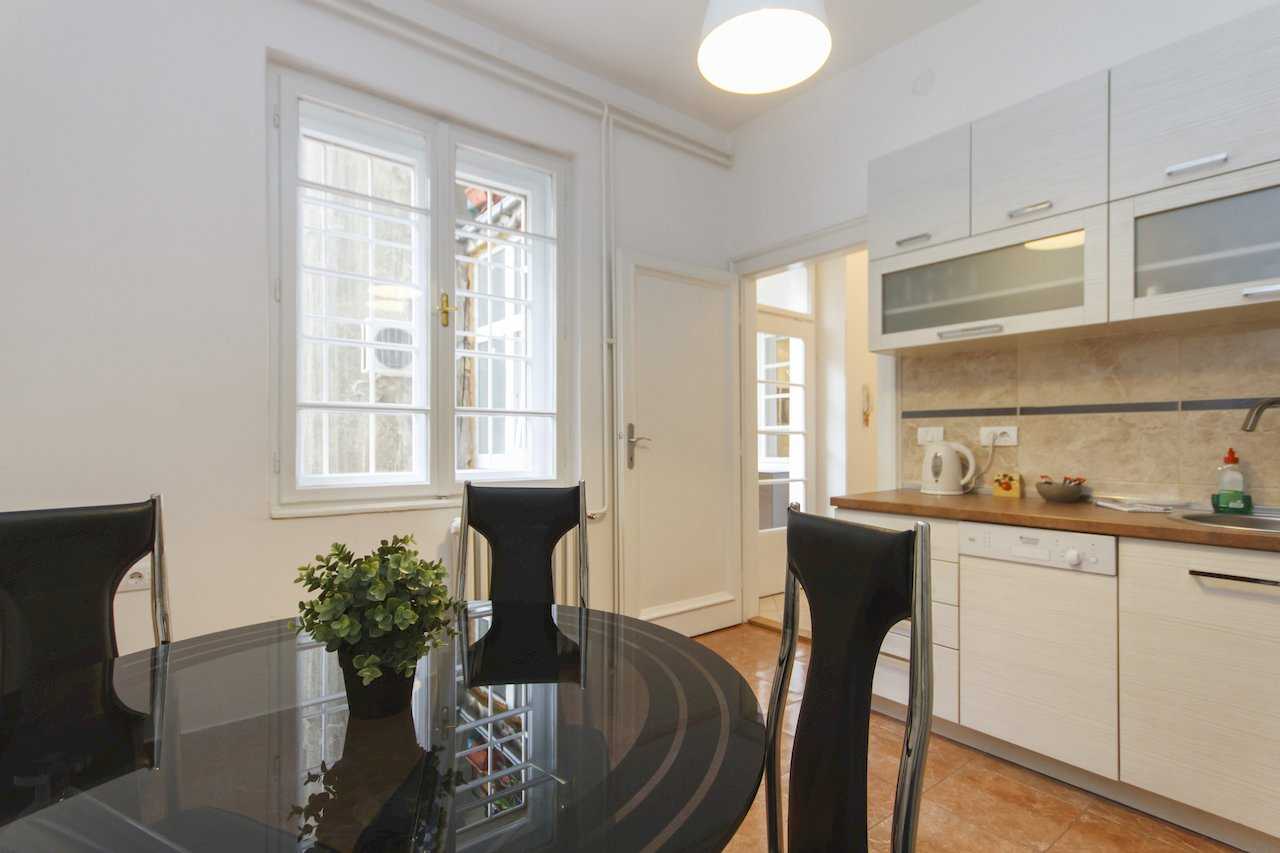 Apartment Parlament 2 (Vlajkovićeva Street, Belgrade) – kitchen and dining space with window and black glass table