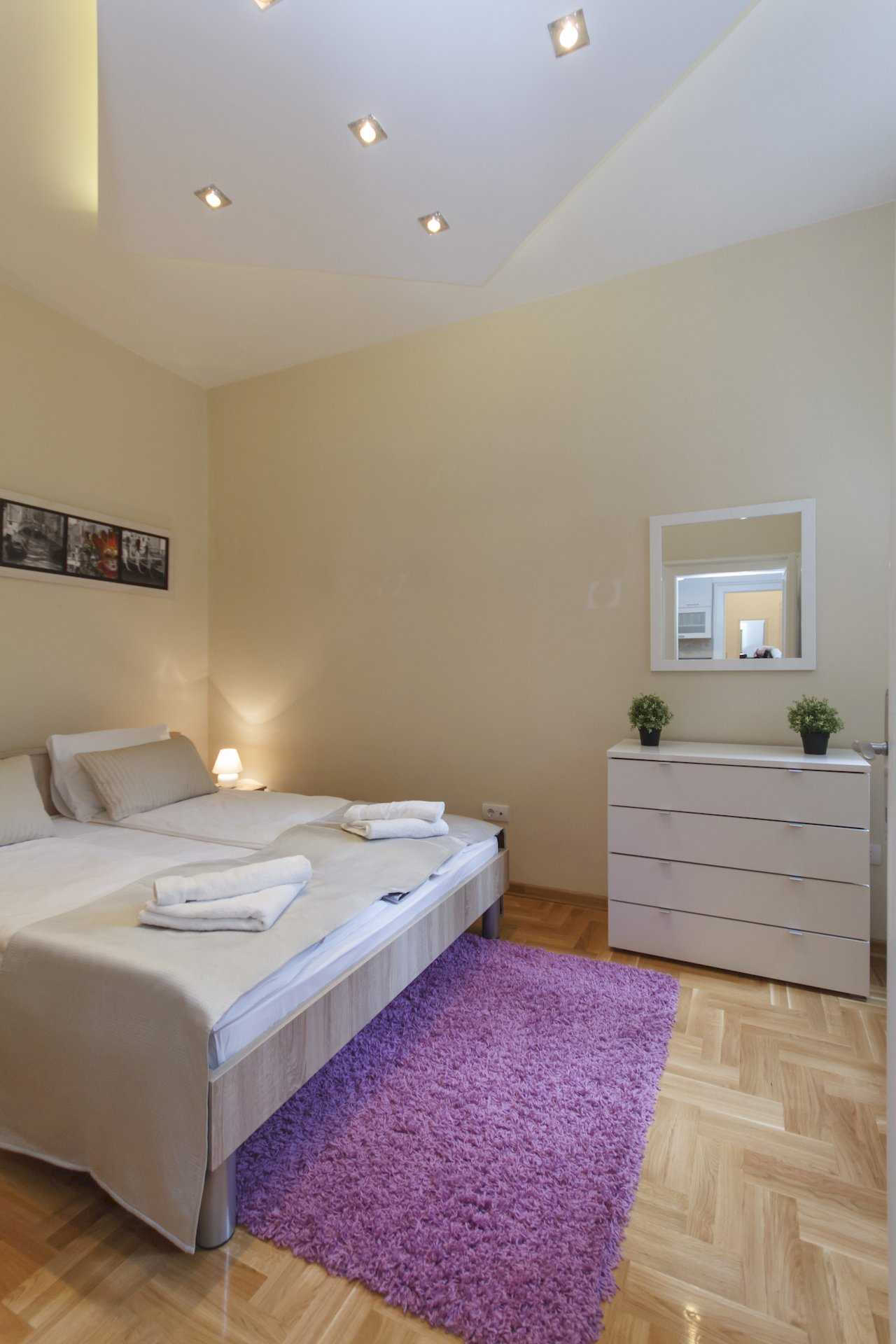 Apartment Parlament 2 (Vlajkovićeva Street, Belgrade) – bedroom with joined beds, purple rug and ceiling spotlights