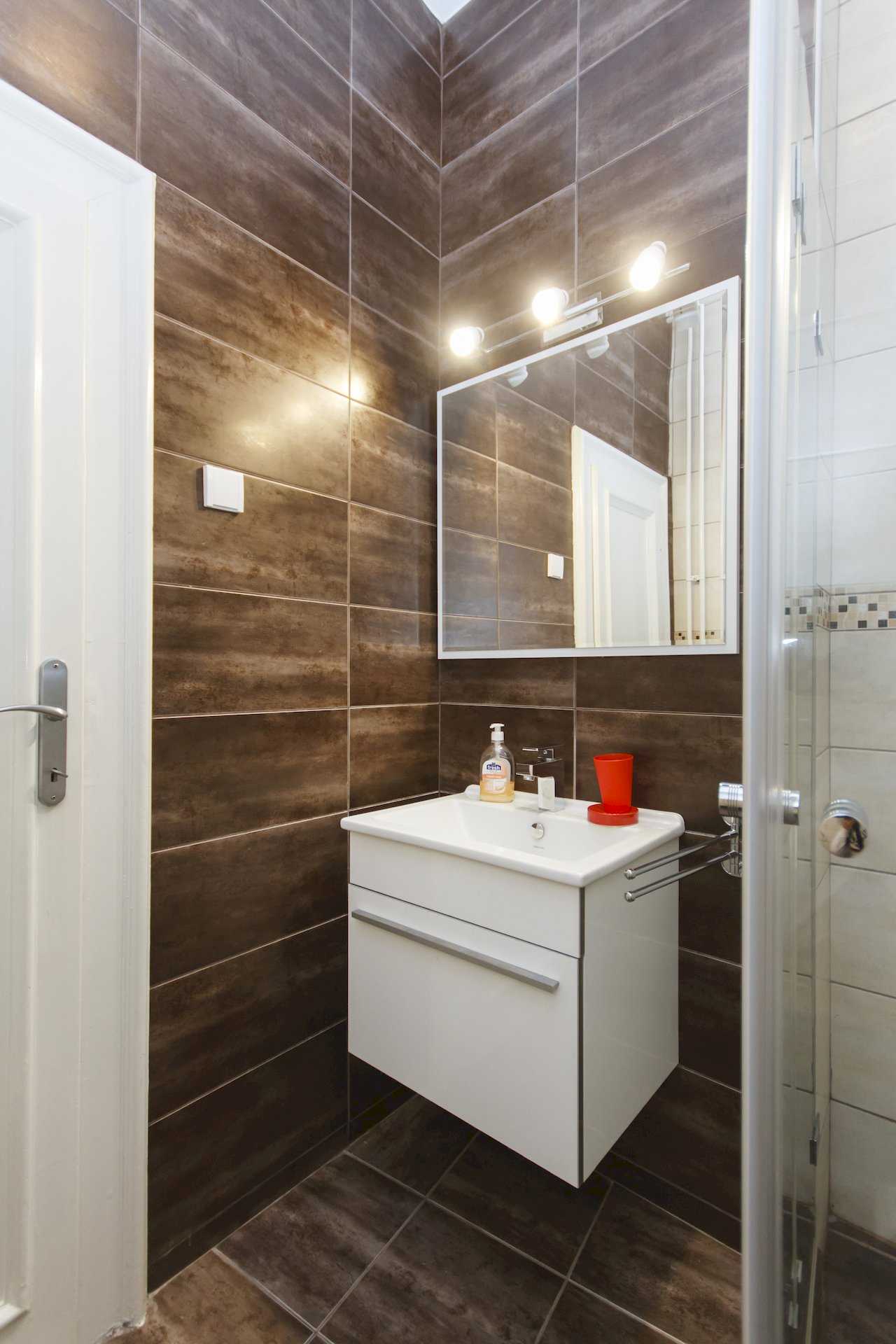 Apartment Parlament 2 (Vlajkovićeva Street, Belgrade) – bathroom with white sink vanity and dark wall tiles