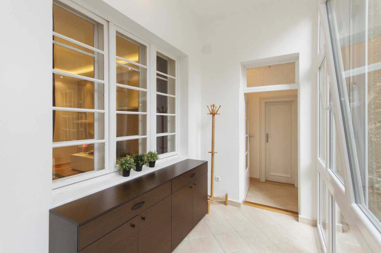Apartment Parlament 2 (Vlajkovićeva Street, Belgrade) – enclosed balcony with dark sideboard, plants and coat stand
