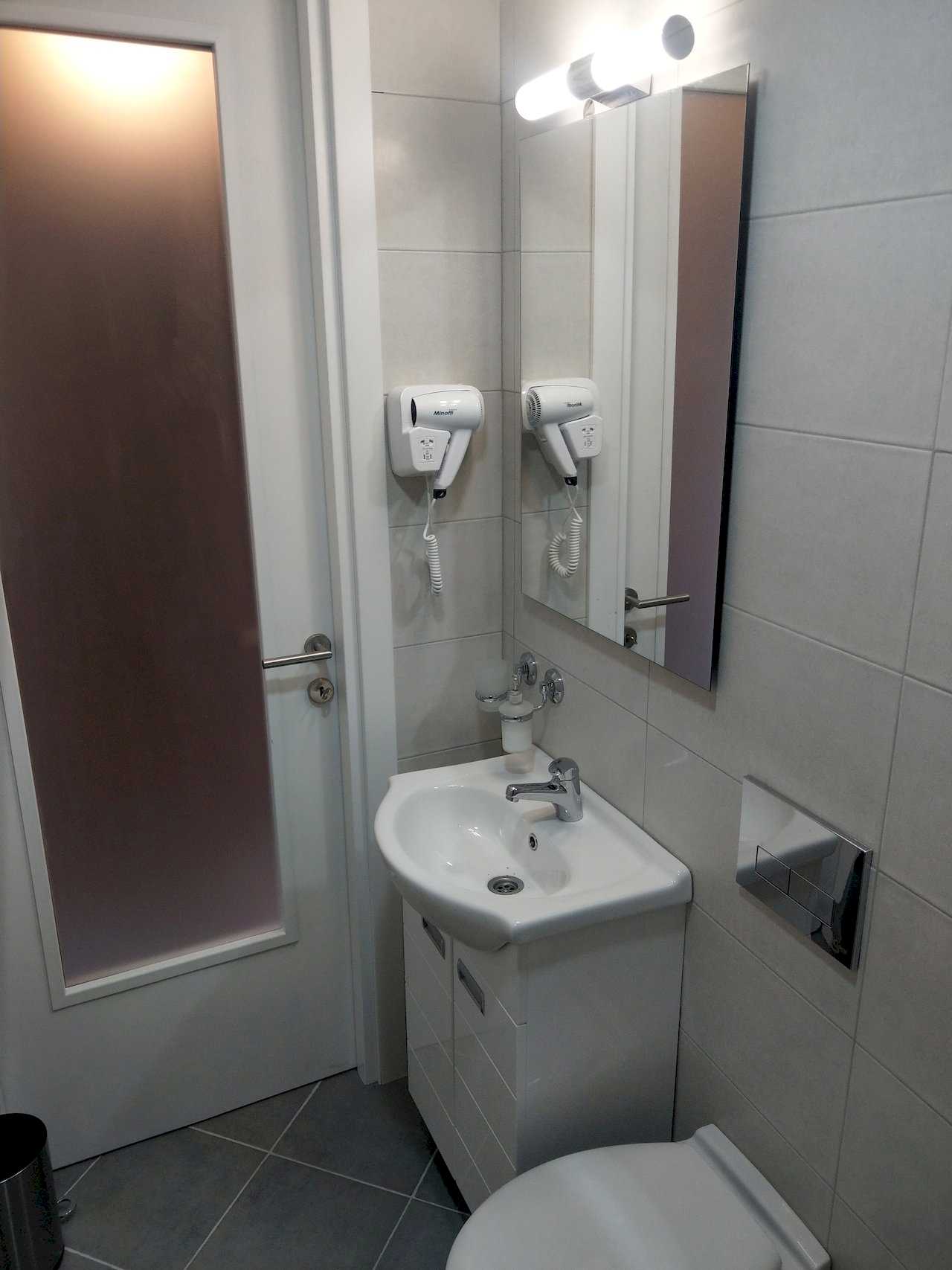 Apartment Pobednik (Hilandarska Street, Belgrade) – bathroom detail: sink, mirror and hair dryer