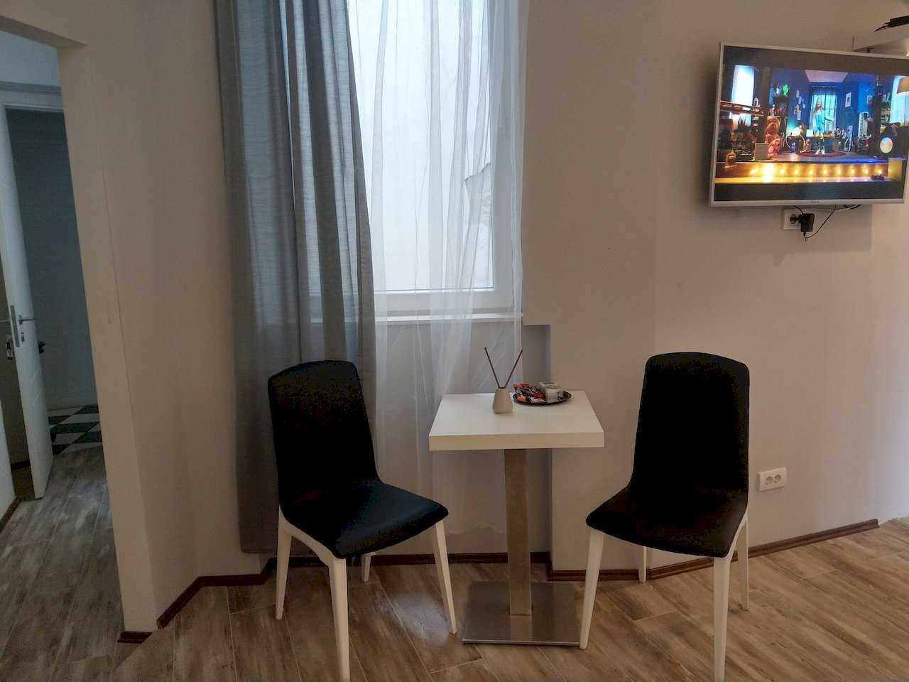 Apartment Pobednik (Hilandarska Street, Belgrade) – table for two by the window, TV on the wall