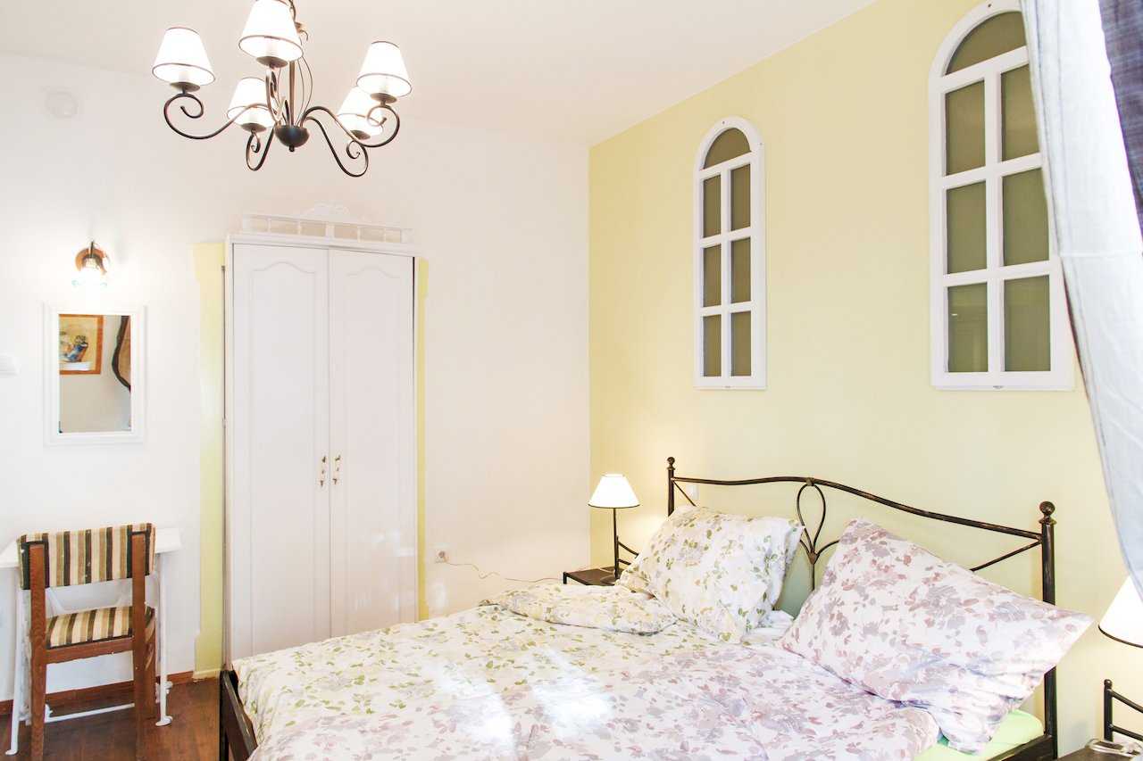 Apartman Sweet (Beograd, centar) – spavaća soba sa bračnim krevetom od kovanog gvožđa, cvetnom posteljinom i belim ormarom