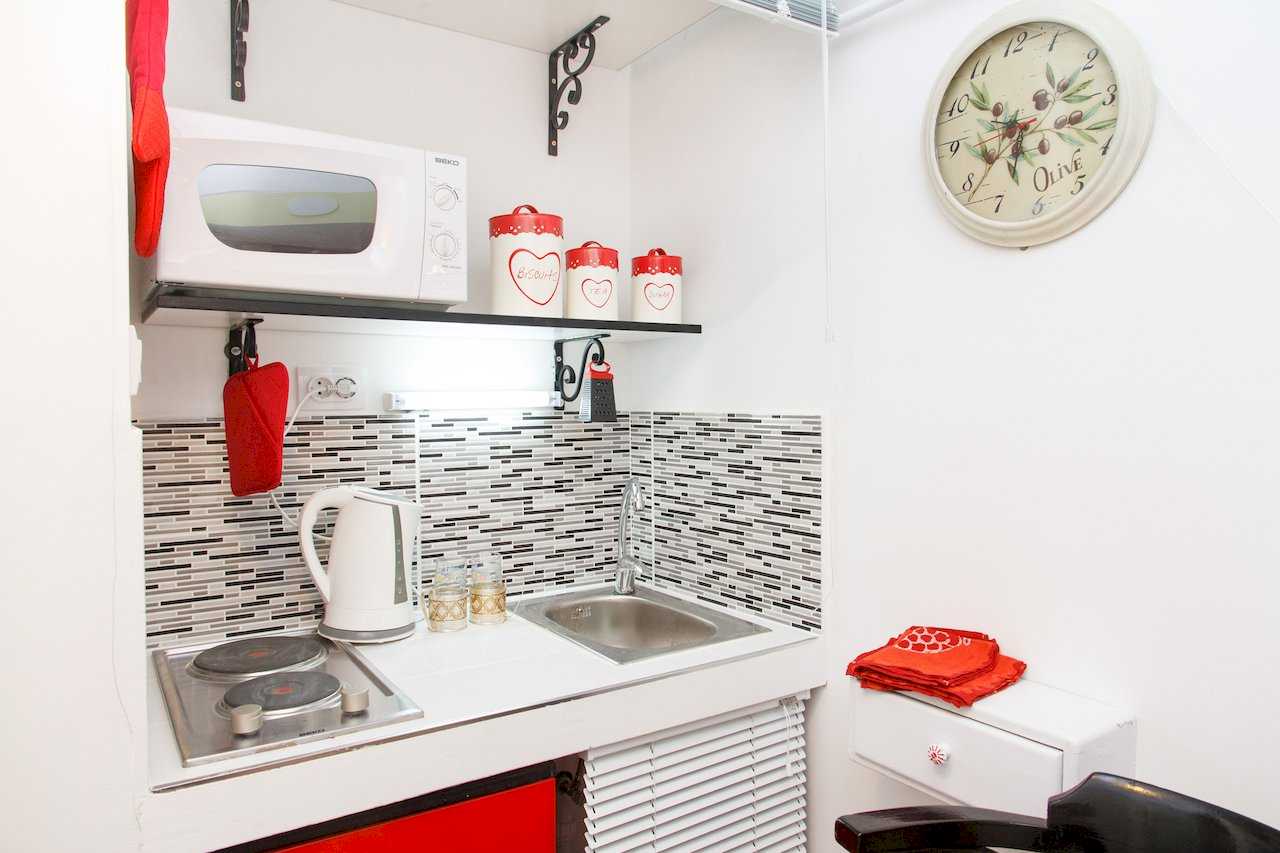 Apartman Sweet (Beograd, centar) – mala čajna kuhinja sa belim elementima, crvenim detaljima i mozaikom