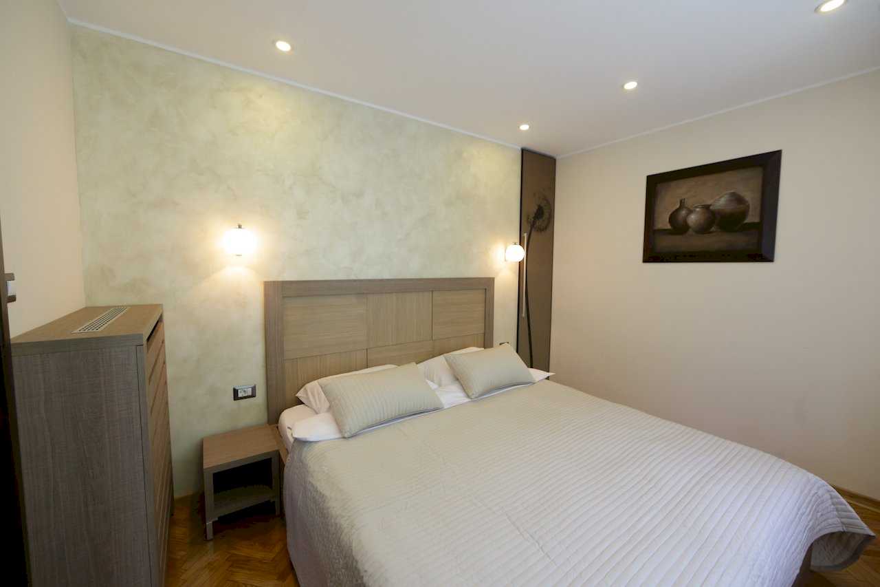 Apartment Taš 2 (King Alexander Boulevard, Tašmajdan, Belgrade) – bedroom with double bed, wooden headboard and framed artwork on the wall